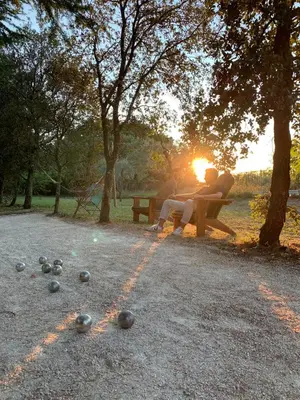 two people sitting on a park bench in the sunset at le Gecko en Provence in La Roque-sur-Pernes