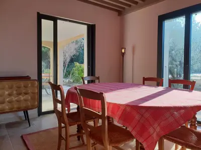a dining room with a table and chairs and a window at le Gecko en Provence in La Roque-sur-Pernes