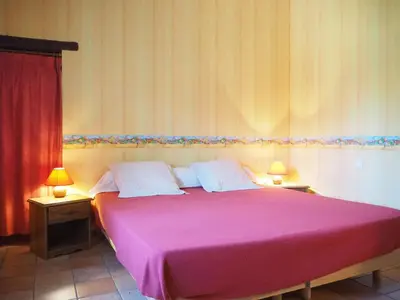 a bedroom with a large pink bed with two lamps at Sunny Provence Home with Terrace in Monteux