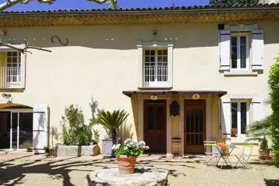a large white house with flowers in front of it at Cozy Noves Home with Pool Access in Noves