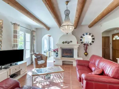 a living room with a red couch and a fireplace at Holiday Home Mas de L'Oulivier by Interhome in Roussillon