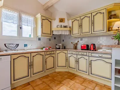 a kitchen with yellow cabinets and a tile floor at Holiday Home Les Iris by Interhome in Gargas