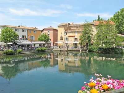 a river in a town with flowers and buildings at Holiday Home Clos Saint Joseph by Interhome in Lagnes