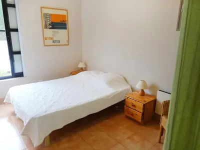 a bedroom with a white bed and a night stand at Holiday Home Villa Isabelle by Interhome in Gondonnets