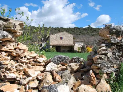 a stone wall with a building in the background at Holiday Home Les Geais by Interhome in Saint-Saturnin-les-Apt