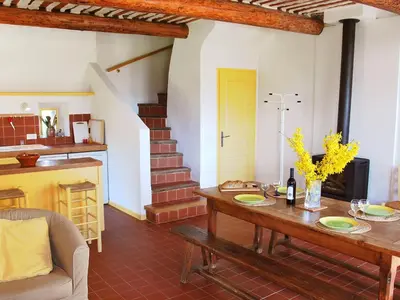 a living room with a wooden table with flowers on it at Holiday Home Les Geais by Interhome in Saint-Saturnin-les-Apt