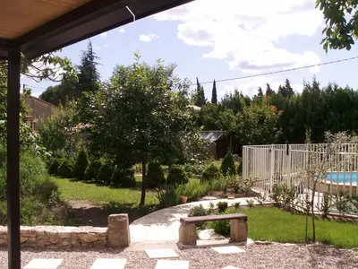 a garden with a bench and a swimming pool at Apartment Haider by Interhome in Caumont-sur-Durance
