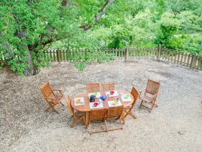 a wooden table and chairs in a yard at Holiday Home Les Cotes by Interhome in Saint-Martin-de-Castillon