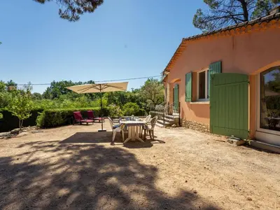 a patio with a table and chairs and an umbrella at Holiday Home Les Ecureuils by Interhome in Saint-Pantaléon