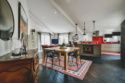 a kitchen and living room with a table and chairs at Escapade en Provence in LʼIsle-sur-la-Sorgue