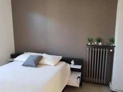 a bedroom with a white bed and a radiator at Location maison Monteux in Monteux
