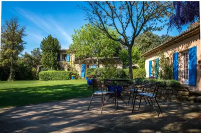 a table and chairs in front of a house at La Ferme in Saint-Marc-Jaumegarde