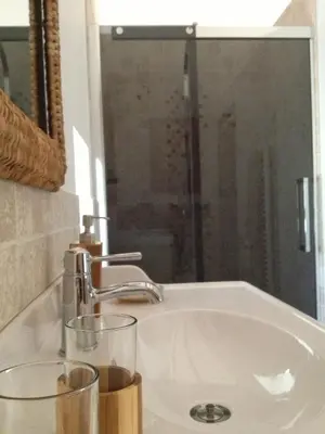 a bathroom sink with two glasses and a mirror at Le Mas d'Hermès in Plan-dʼOrgon