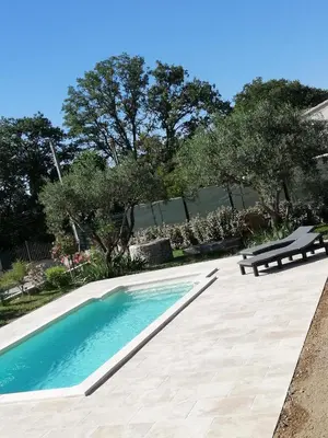 a swimming pool with a bench and trees in the background at Sophie et Jamiel in Eyragues