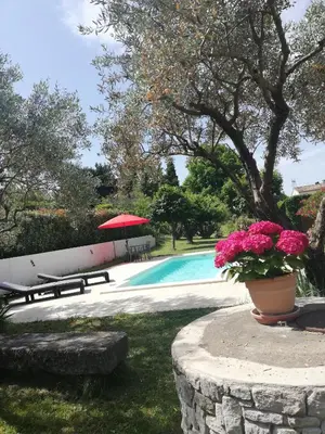 a pool with a table and flowers in a yard at Sophie et Jamiel in Eyragues