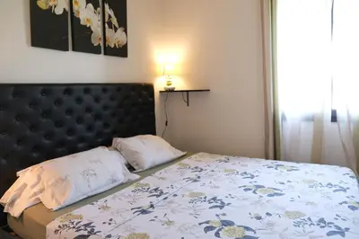 a bedroom with a bed with a black headboard at charming family house with pool located at L'isle sur la sorgue - sleeps 8 in LʼIsle-sur-la-Sorgue