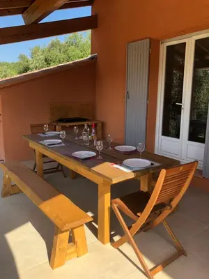 a wooden table with two chairs and a table and a table and chairsktop at La Maison Bougnette in Flassan