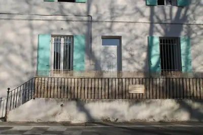 a fence in front of a building with windows at Au bonheur de LILI in Fontaine-de-Vaucluse