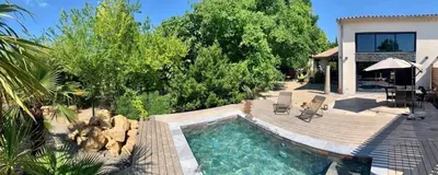 a backyard with a swimming pool and a house at Villa en campagne avec piscine et jacuzzi in Aix-en-Provence