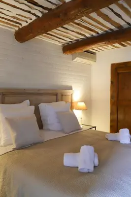a bedroom with a large bed with towels on it at LA FERME DE LA HUPPE in Gordes