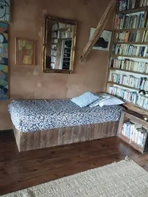 a bed in a room with a book shelf at Entre Terre et Ciel. in Saignon