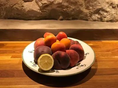 a bowl of fruit on a plate with a lemon at la bonbonniere - Townhouse Saint-Saturnin-lès-Apt in Saint-Saturnin-les-Apt