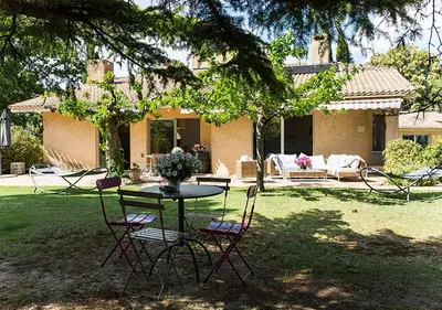 a table and chairs in the yard of a house at Au Coeur des Vignes en Provence in Châteauneuf-de-Gadagne