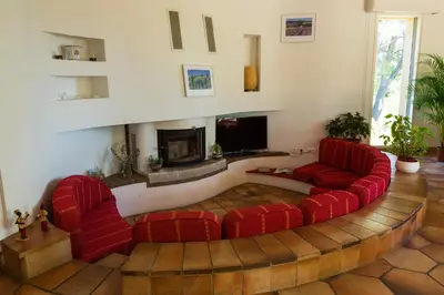 a living room with red couches and a fireplace at Au Coeur des Vignes en Provence in Châteauneuf-de-Gadagne
