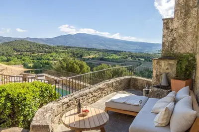 a patio with a couch and a table and a view at Maison Ventoux in Crillon-le-Brave