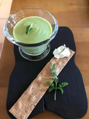 a plate with a bowl of green liquid and a bowl of dip at FOUR DE CONY in Saumane-de-Vaucluse
