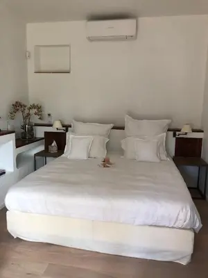 a large white bed with a stuffed animal sitting on it at FOUR DE CONY in Saumane-de-Vaucluse