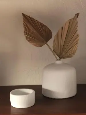 a white vase with a plant in it on a table at FOUR DE CONY in Saumane-de-Vaucluse