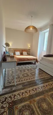 a bedroom with a bed and a table in a room at La Bastide des Arts in Saumane-de-Vaucluse