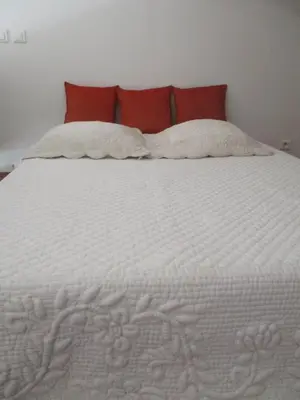 a large white bed with two pillows on it at Gîte du Jardin des Espuys in Venasque