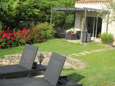 two chairs sitting on a patio in a yard at Gîte du Jardin des Espuys in Venasque