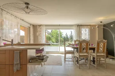 a kitchen with a table and a refrigerator at Maison Beally in Eyragues
