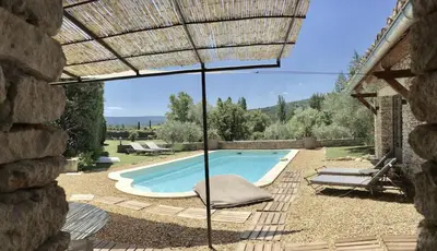 a swimming pool with a chair and an umbrella at Le Mas les Pléiades - Private pool - Gordes in Gordes