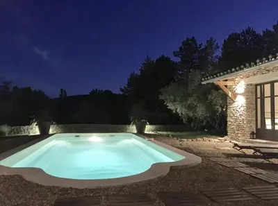 a swimming pool in a yard at night at Le Mas les Pléiades - Private pool - Gordes in Gordes