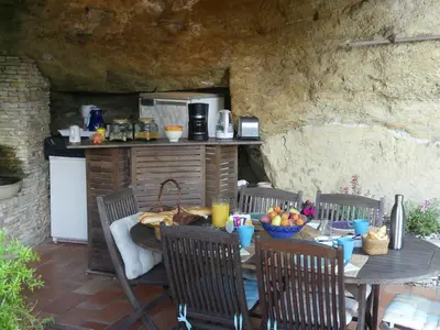 an outdoor table and chairs with a table and a kitchen at les 3 saisons in Cucuron