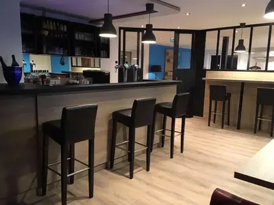 a bar with black bar stools in a kitchen at Brit Hotel Salon de Provence in Salon-de-Provence