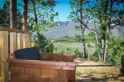 a cabin in the woods with a tree at Camping le Colorado in Rustrel