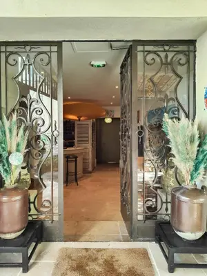 an open door with two potted plants in a hallway at Hostellerie Le Paradou in Lourmarin