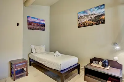 a small bedroom with a bed and a table at Hostellerie Le Paradou in Lourmarin