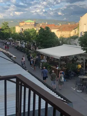 a group of people walking down a street with a tent at 13 QUAI JEAN JAURES in LʼIsle-sur-la-Sorgue