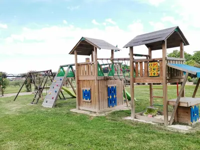 a group of playground equipment in a field at Gîte en Provence Lavande in Modène