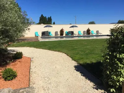 a house with chairs and umbrellas in a yard at Large family home with private pool in Vignères, 10 sleeps. in Cavaillon