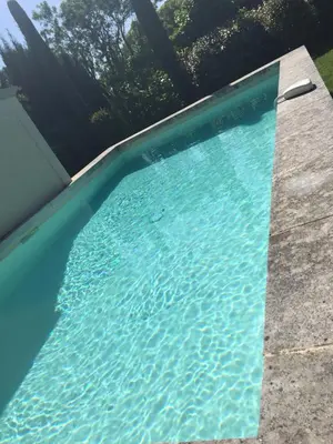 a swimming pool with blue water in a yard at Loft 52 in Aix-en-Provence
