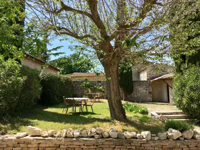 a table and chairs under a tree in a yard at Domaine de Carraire in Aix-en-Provence