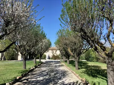 a road with trees and a bridge in the background at Domaine de Carraire in Aix-en-Provence