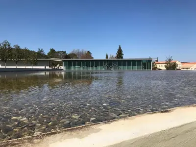 a large body of water with a building in the background at Il Sole in Le Puy-Sainte-Réparade